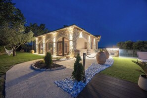 A stone building with arched doorways, a paved pathway, and outdoor seating. - Villa in Canale with 5 bedrooms sleeps 14 (Canale)