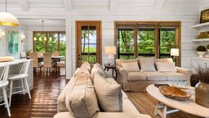 Une pièce spacieuse avec un plafond en bois, un coin repas et un espace détente comprenant un canapé et une table basse.