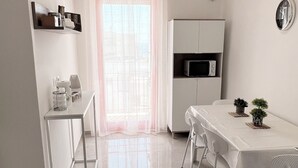 A modern kitchen with a dining area, a microwave, and a small potted plant. - Your vacation in Otranto a stone's throw from the sea and the historic center (Otranto)