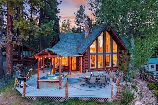 Twinkling lights, a private hot tub, and soaring windows make this mountain cabin the perfect place to unwind after a day of adventure.