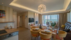 Ein modernes Wohnzimmer mit Essbereich, Kamin und großem Fenster mit Vorhängen.