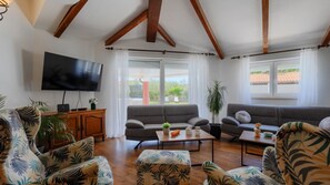 A living room with a TV, sofas, a coffee table, and a cabinet. - Casa Luce by Villas Guide (Pula)