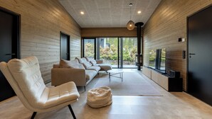 A modern living room with a sofa, chairs, a coffee table, and a television. - Villa Noel A  (Lappi)