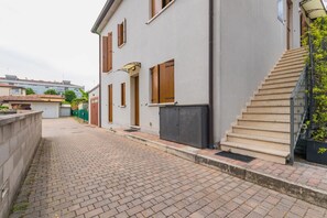 Ein schmaler Gang mit einem Gebäude, das eine Treppe und eine Tür zeigt.
