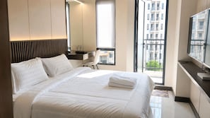 Une chambre d’hôtel moderne équipée d’un grand lit, d’un bureau, d’une chaise et d’un téléviseur.
