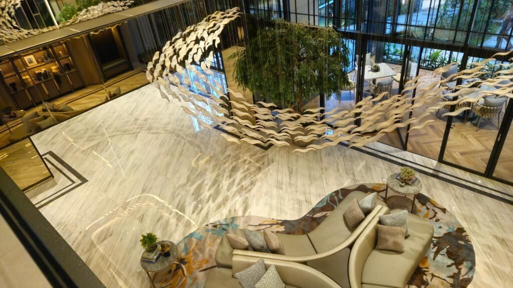 Un vestíbulo espacioso con una zona de estar central, una planta de interior grande y un diseño moderno.