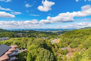 A residential area with a mix of houses and buildings, surrounded by greenery and hills. - ARIMA ONSEN WARAYA JINSEN (Kobe-shi)
