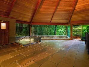 A spacious interior with a stone floor, a wooden ceiling, and large windows offering a view of bamboo outside. - ARIMA ONSEN WARAYA JINSEN (Kobe)