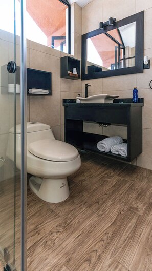 A modern bathroom with a toilet, sink, and mirror. -  Casa BuenaVida - 4BR Luxury Retreat (Quito)