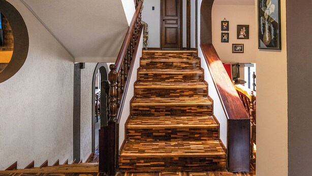 A staircase with wooden steps and a wooden handrail. - Casa BuenaVida  (Quito)