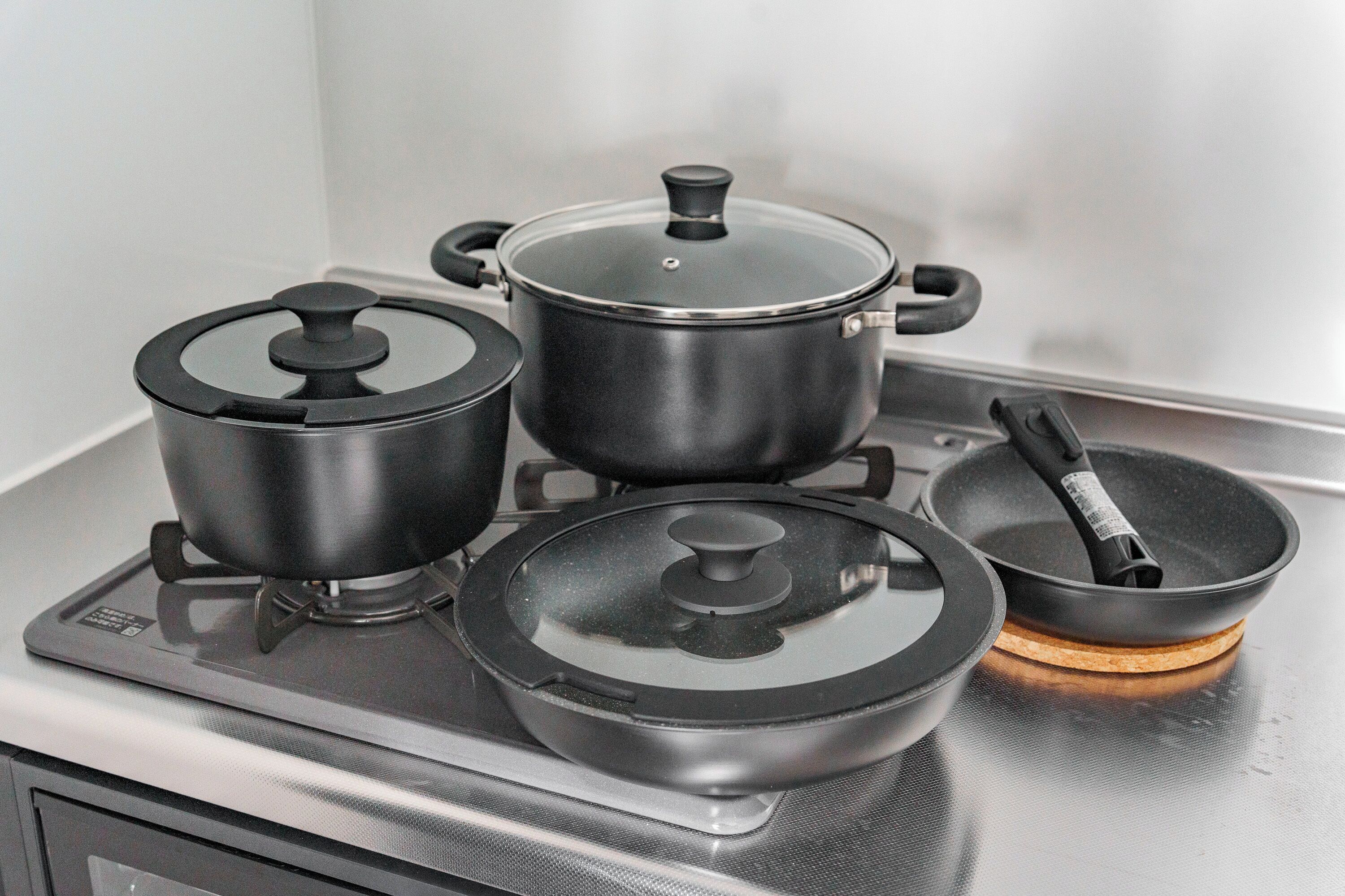 Una cocina con estufa, ollas y sartén.