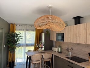 A modern kitchen with a wooden countertop, a built-in oven, and a hanging light fixture.