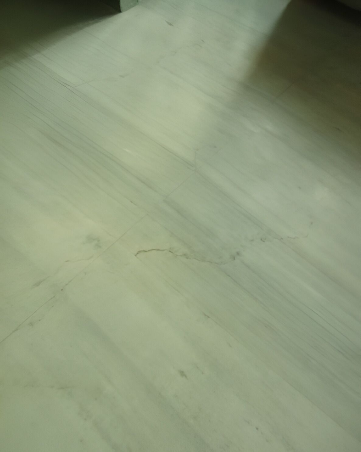 Piso de madeira com riscos e marcas visíveis.
