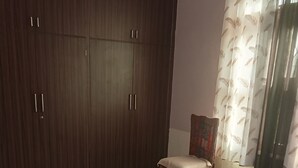 Un dormitorio con armario, cama y una silla.