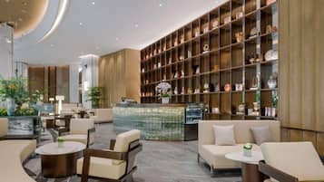 Eine moderne Lobby mit Sitzgelegenheiten, einem Empfangsbereich und einem großen Regal mit Dekoration.