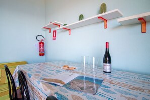 A dining area with a table set for two, a fire extinguisher, and cactus decorations on shelves. - Casa Libeccio - Pistis - wifi - Pet Friendly (Arbus)