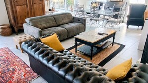 A living room with a sectional sofa, a coffee table, and a dining area with chairs. - T3 Dolce Bateau, a 5-minute walk from the 3*-rated lake (Aix-les-Bains)