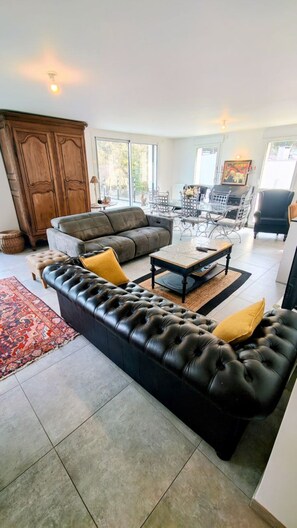 A living room with a sectional sofa, a coffee table, and a dining area with chairs. - T3 Dolce Bateau, a 5-minute walk from the 3*-rated lake (Aix-les-Bains)