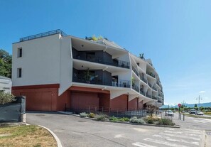 A multi-story building with balconies, a garage, and a clear sky. - T3 Dolce Bateau, a 5-minute walk from the 3*-rated lake (Aix-les-Bains)