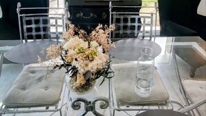 A dining area with a glass table, black chairs, a floral centerpiece, and a painting above the table. - T3 Dolce Bateau, a 5-minute walk from the 3*-rated lake (Aix-les-Bains)