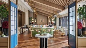 A bar area with a round table, multiple chairs, and a variety of bottles.