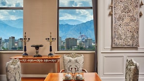 A room with a view of mountains and a cityscape through large windows, a table with decorative items, and a patterned wall hanging. - voco Lhasa Chengguan by IHG (Lhasa)