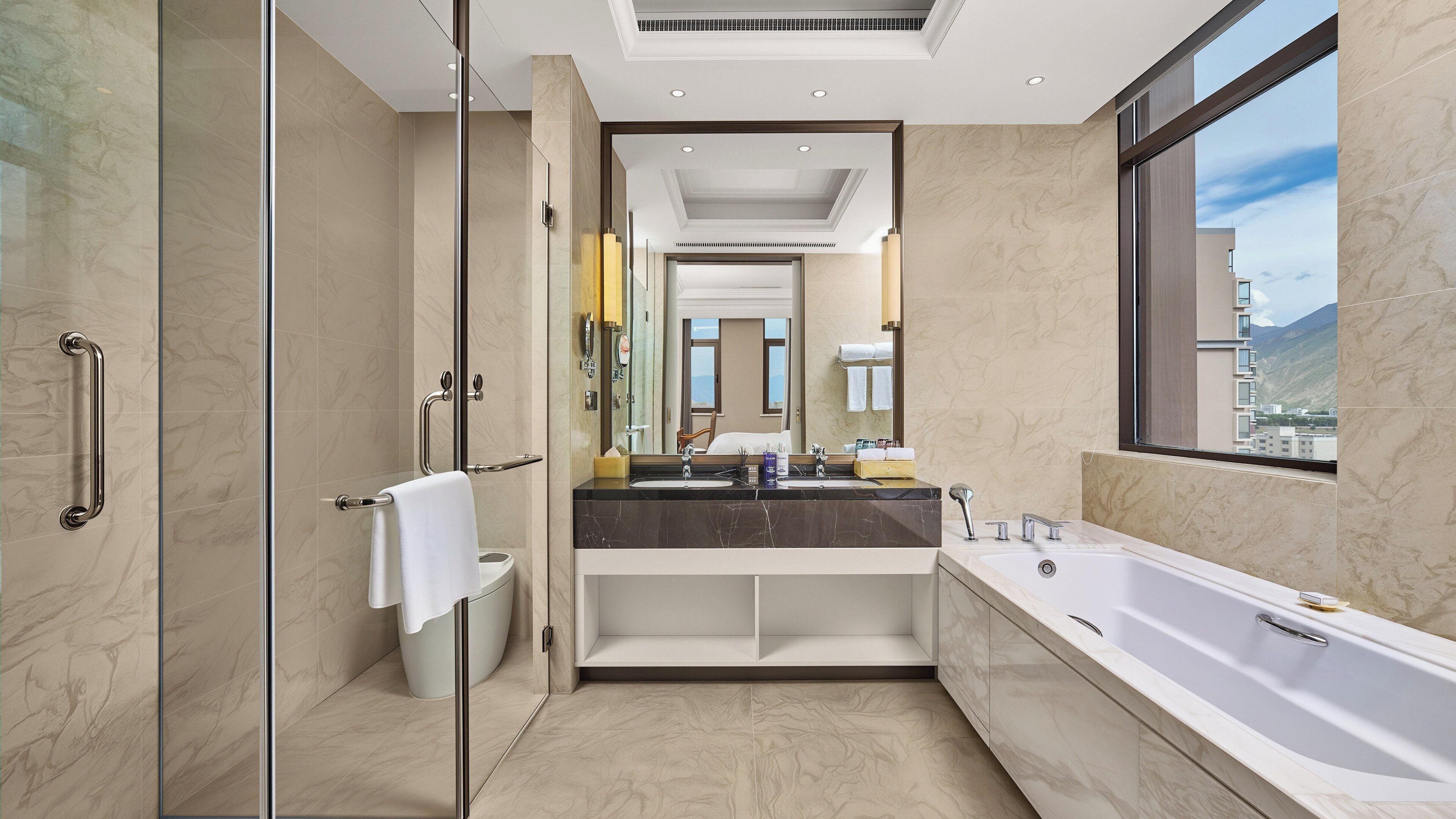 A modern bathroom with a glass shower enclosure, a large bathtub, and a dual sink vanity.