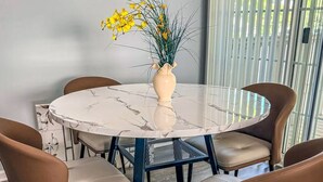 A round table with a marble top and a vase with yellow flowers. - Nyakio Suite - Chesapeake (Chesapeake)