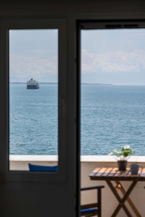 Blick auf das Meer vom Balkon aus, ein Schiff in der Ferne.