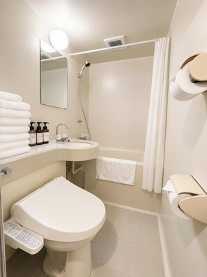 Et moderne badeværelse med toilet, håndvask og bruser.