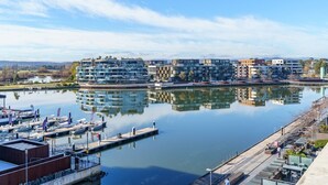 A marina with boats docked, a waterfront promenade, and modern buildings with balconies. - Sub-Penthouse with Lake Views | Kingston Foreshore (Kingston)