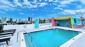 Piscina no terraço com horizonte urbano ao fundo.