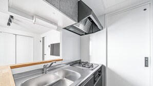 Una cocina moderna con un lavamanos de acero inoxidable, una campana extractora y una encimera de madera.