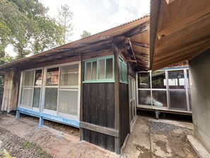 Un edificio de madera con ventanas amplias y un porche cubierto.
