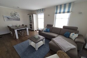 Ein Wohnzimmer mit einer Couch, einem Esstisch und einem Couchtisch.