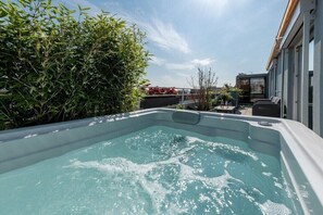 Ein Whirlpool mit Blick auf ein Gebäude und Grünflächen.