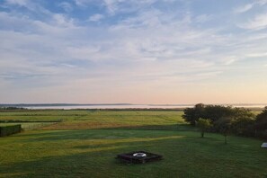 A grassy field with a small structure and a tree. - Holiday apartment in Rieth with swimming pool (Rieth)
