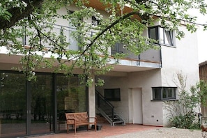 A modern building with a glass entrance, a wooden bench, and a staircase leading to an upper level. - 1 - Langerwisch Manor (Michendorf OT Langerwisch)