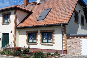 Ein zweigeschossiges Haus mit Ziegeldach, Backsteinverzierungen und einer Satellitenschüssel.