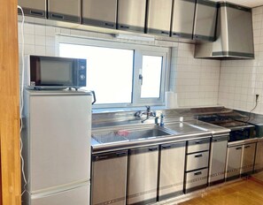 A modern kitchen with stainless steel appliances, a window, and a sink. - TSUGARU HOUSE 2  A private villa rental in Aomori / Aomori City Aomori (Aomori City)