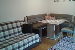 Ein kompakter Wohnbereich mit einer Couch, einem kleinen Tisch und einer Bank.