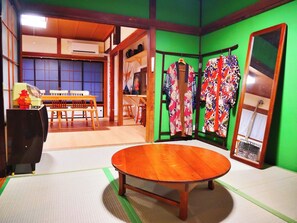 Ein traditioneller japanischer Raum mit Tatami-Bodenbelag, einem Holztisch und einer grünen Wand.