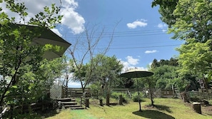 A backyard with a wooden deck, a pergola, and a gazebo.