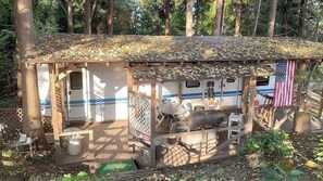 Une petite construction en bois dotée d’un porche abrité, d’un barbecue et d’un drapeau américain.