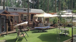 Ein Garten mit Trampolin, Tischtennisplatte und überdachter Sitzgelegenheit.