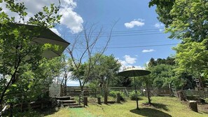 A backyard with a wooden deck, a pergola, and a gazebo.