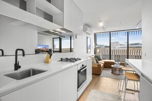 Eine moderne Küche mit einer großen Kochinsel, einem Essbereich mit Barhocker und einer Couch.