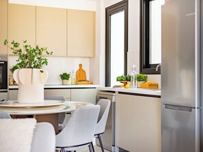 Uma cozinha moderna com área de jantar, apresentando uma mesa redonda, cadeiras e um vaso com planta.