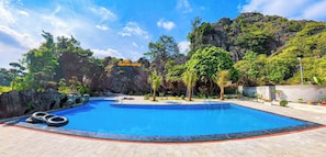 Une piscine offrant une vue sur un paysage montagneux, avec un panneau indiquant « Sunrise Valley ».