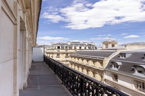 Ein Balkon mit Blick auf historische Gebäude und einen klaren Himmel.